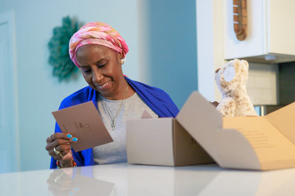 Cancer survivor smiling as she reads her a Teddy Prayer Prayer Bear card.